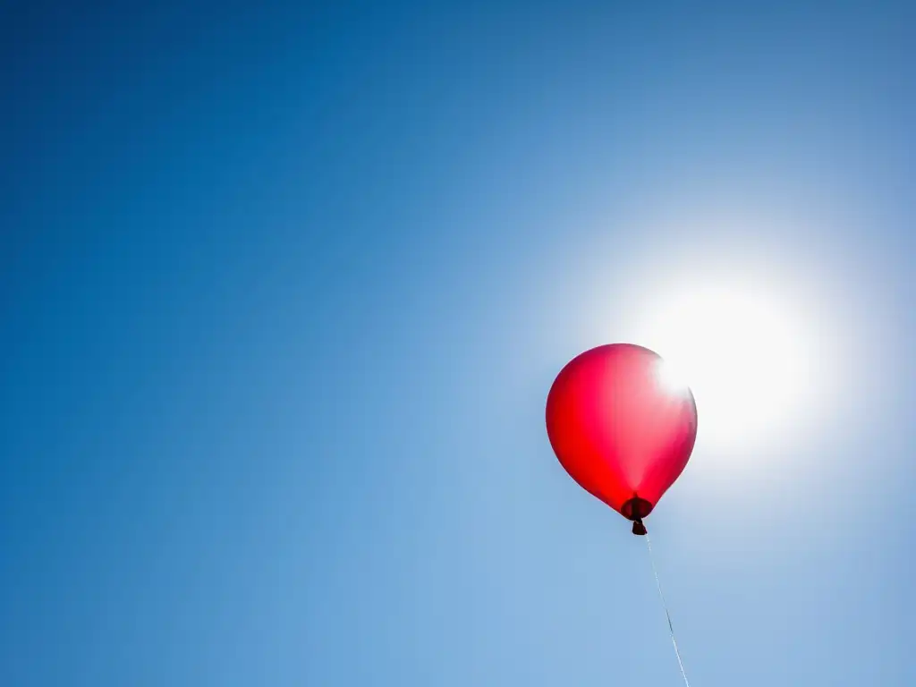 Imagen motivadora: globo rojo flotando en el cielo azul