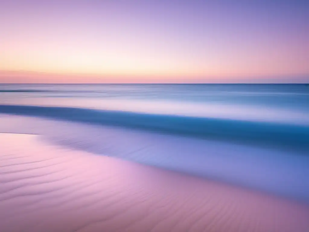 Importancia habilidades blandas bienestar emocional: imagen de un océano azul sereno con suaves olas en una playa de arena, cielo rosado y morado